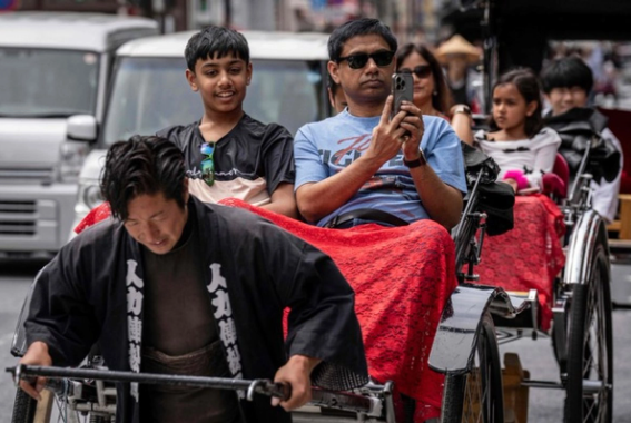 Turistas extranjeros pasean en bicitaxis en Asakusa, Tokio, representando el crecimiento del turismo mundial en 2025